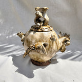 “Grão a grão enche a galinha o papo” — "Grain by grain, the hen fills her crop.”