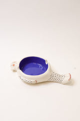 white ceramic ashtray shaped like lying man