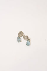Pair of silver earrings with blue gemstones on a white background